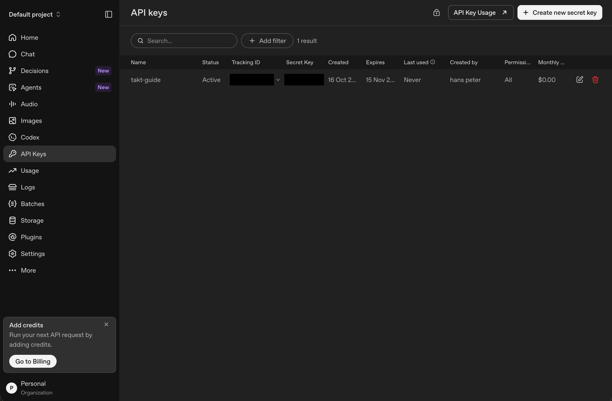 The OpenAI API keys page with the new key listed, its tracking ID and key covered.